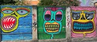 Trio of street art with teeth and eyes prominent in each
